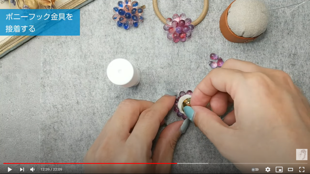 ビーズを縫い付けたフェルトに金具を付ける様子