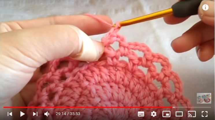 ピンクの毛糸で花のモチーフを編んでいるところ