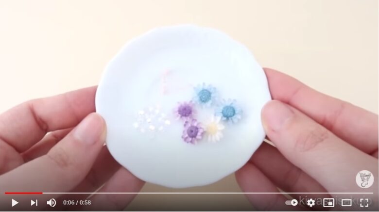 ガラスボールの中に入れる、青・白・紫のスターフラワーと、白のカスミソウが小皿に乗っている写真