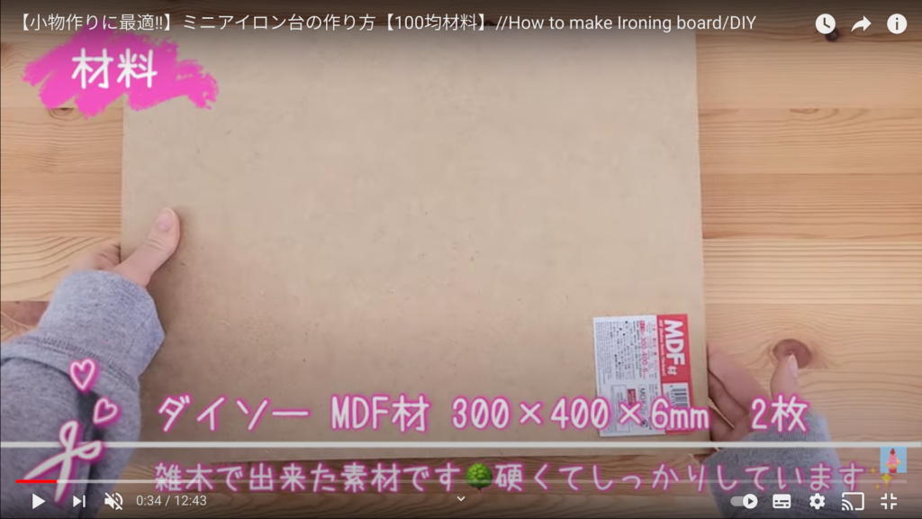 ダイソーのMDF木材2枚の説明をしている、硬くてしっかりしていると字幕あり