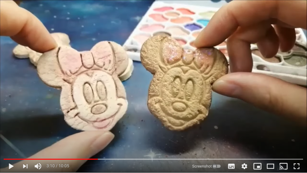 着色済みの2つのフェイククッキーを両手で持っている様子。
1つはキャラクターの配色に合わせて着色し、もう1つはクッキーのような黄土色をメインに着色している。