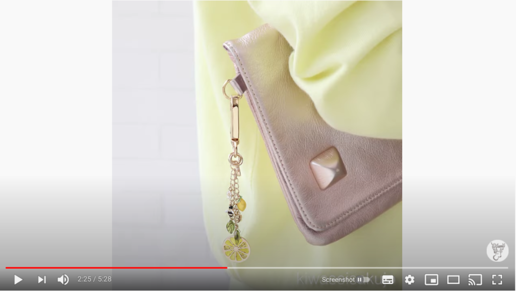 完成したレモンのバッグチャームを、ゴールドのバッグに取り付けている写真。バッグチャーム自体に長さがあるため、歩くとユラユラと揺れて可愛い。