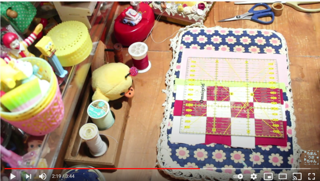 作業台の上に縫い合わせた布が置かれている様子。布の上には、15cm×15cmの正方形の定規が置かれていている。