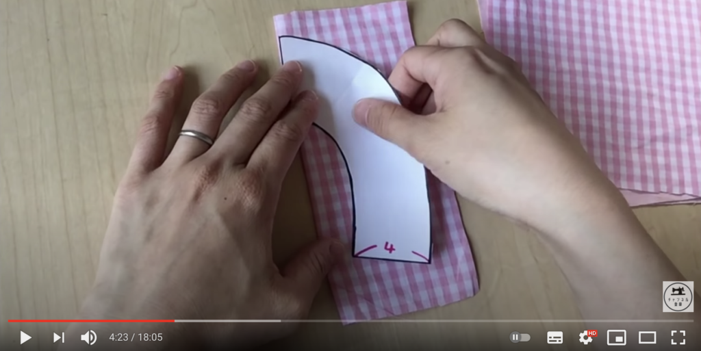 表を内側にして布を半分に折り、型紙を合わせて固定してください。