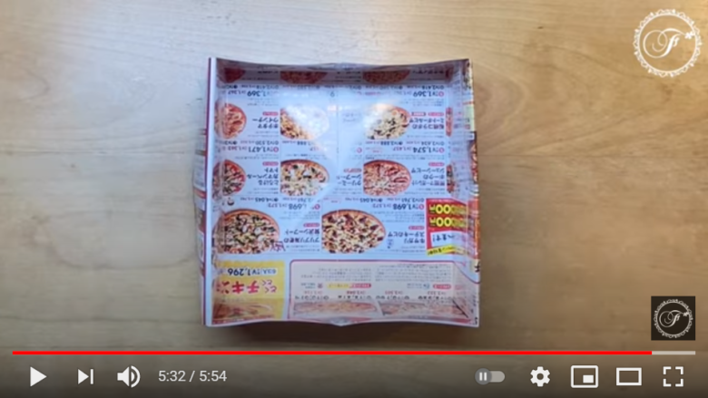 チラシを使ったゴミ箱の完成品を披露している場面。箱はピザの広告で作られており、ある程度の深さを持った、真四角のタイプであることが分かる。