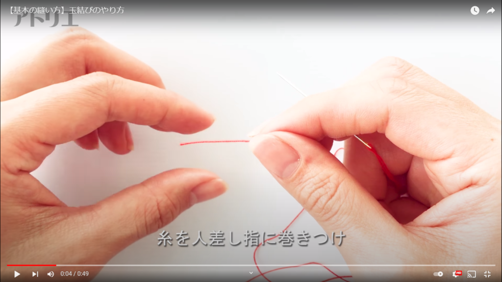 玉結びのファーストステップ、人差し指に糸を巻き付けている様子を拡大したシーン。