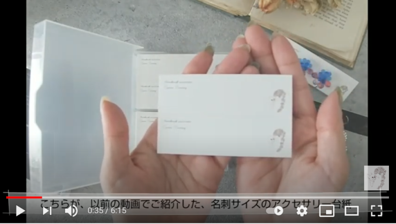 小さな台紙のラッピング方法を紹介しようとしている場面。画面上にはカードケースに入れられた台紙と、それを1枚手にしている投稿者の手元が映り込んでいる。