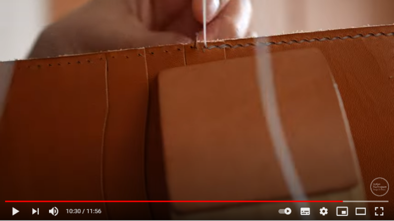 パーツを縫い合わせている場面。手帳ケース本体にいくつかポケットが貼り付けられており、それを固定するために縫おうとしているところがアップで映し出されている。