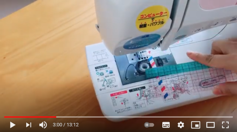 同じ幅の縫い代で縫う時の裏技について、解説しようとしている場面。画面にはボビンケースの近くにマスキングテープが貼られたミシンが映り込み、投稿者がその辺りに定規を当てている様子も窺える。