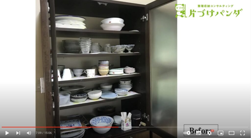 片付け前の食器棚の写真。茶色の食器棚の中にたくさんの和皿やカップなどが入っています。