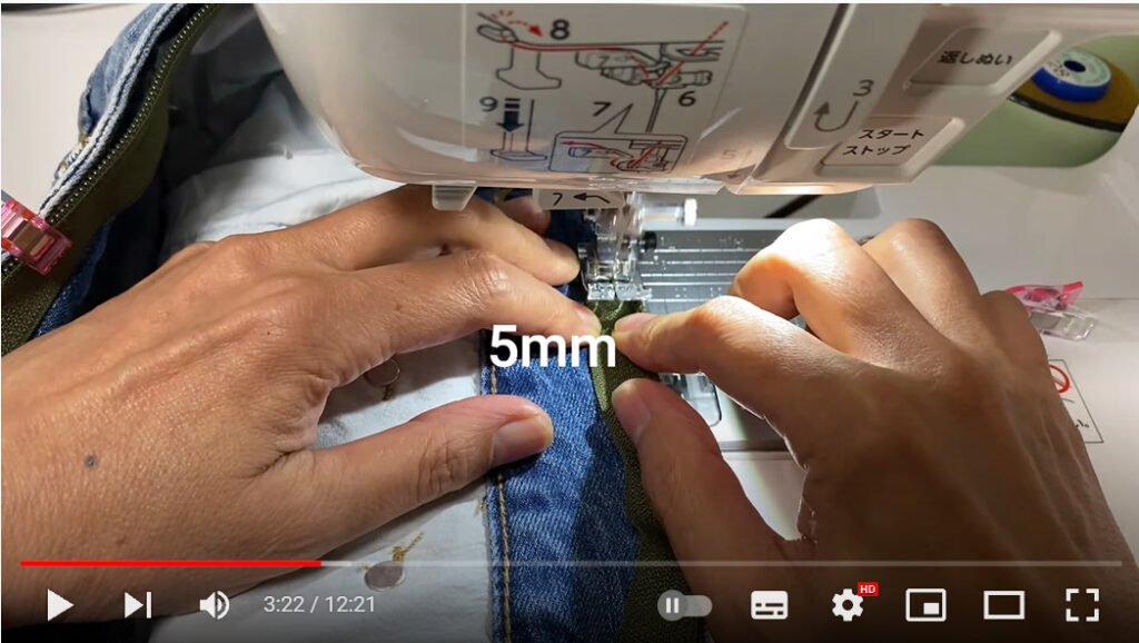 デニムのウエスト部分にミシンでファスナーを縫い付けている写真です。5ミリと表示があり、5ミリ内側を縫えばよいことが分かります。