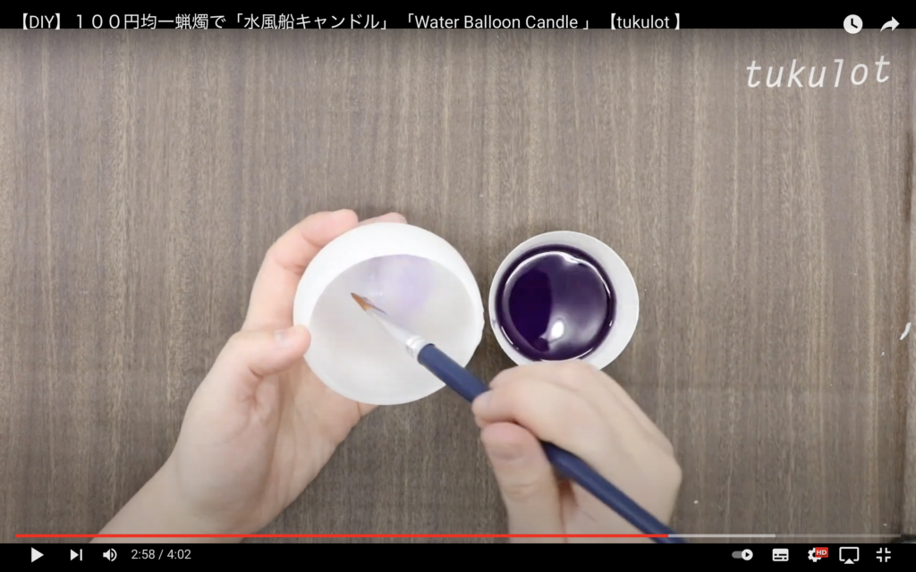 蝋の器の内部に、湯煎して液状にした紫蝋を筆で塗りつけている画像。