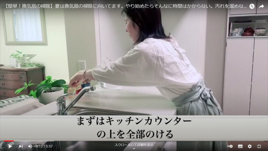 換気扇の部品を置く場所を作るために、キッチンカウンターの上に置いてある物をどかしている山本さん。