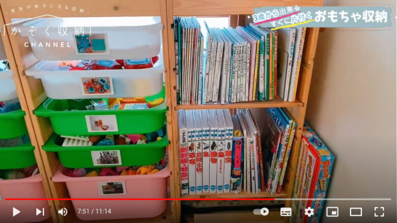収納棚に収納ケースに入れられたおもちゃと本が並んでいます