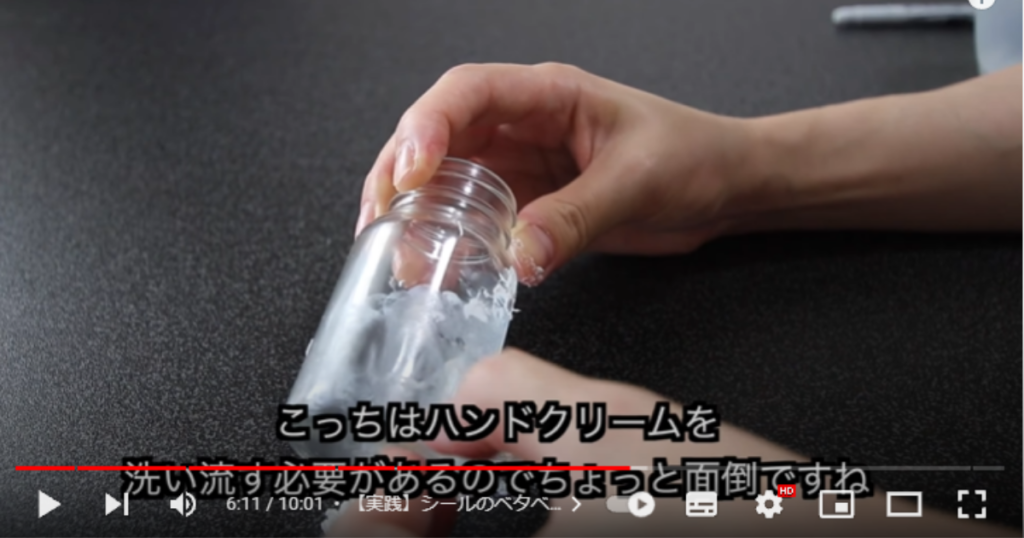 1本目のガラス瓶のシールに、ハンドクリームを塗って剥がしている場面です。