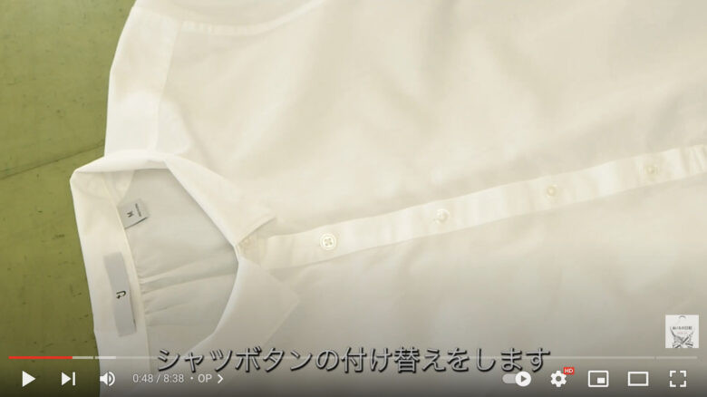 白いシャツが広げてあります。前合わせの部分には一般的な白いボタンが付いています。