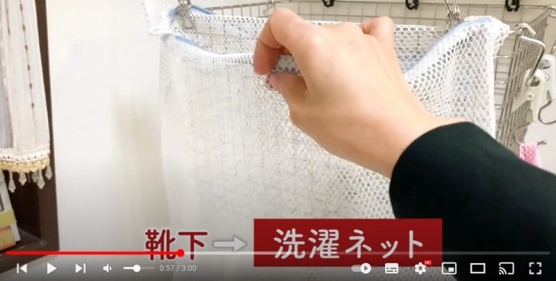 江川さんが、洗濯かごに洗濯バサミで留められている洗濯ネットには、靴下を入れるということを説明しています。