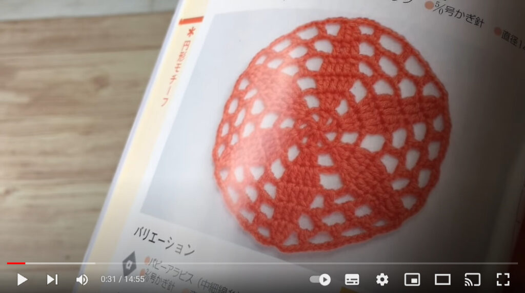 編み物の本の1ページのアップです。赤色の円形のモチーフ編みが写っています。