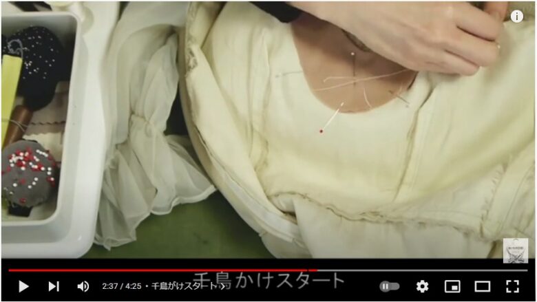 白いドレスベージュの胸当て生地をまち針で固定し、縫っている様子