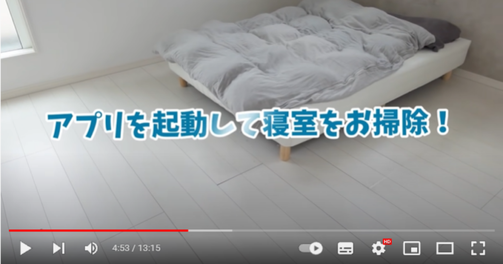 寝室の映像で、部屋の右角にベッドが置かれている様子です。画面テロップには「アプリを起動して寝室をお掃除！」と表示されています。