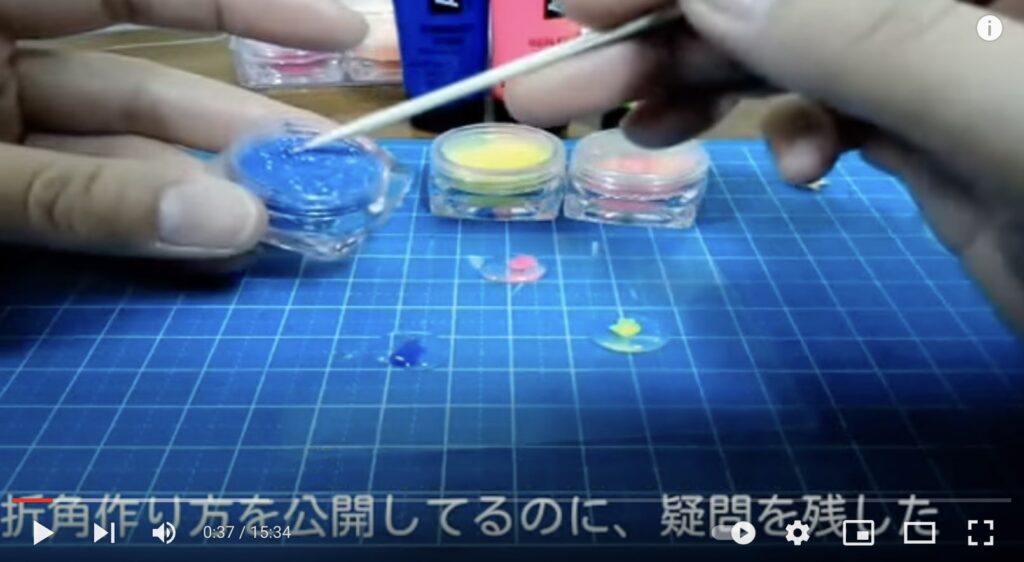 作業マットの上でレジン液をカラーリングパウダーで着色している写真。カラーリングパウダーは青、黄色、ピンクの3色あります。