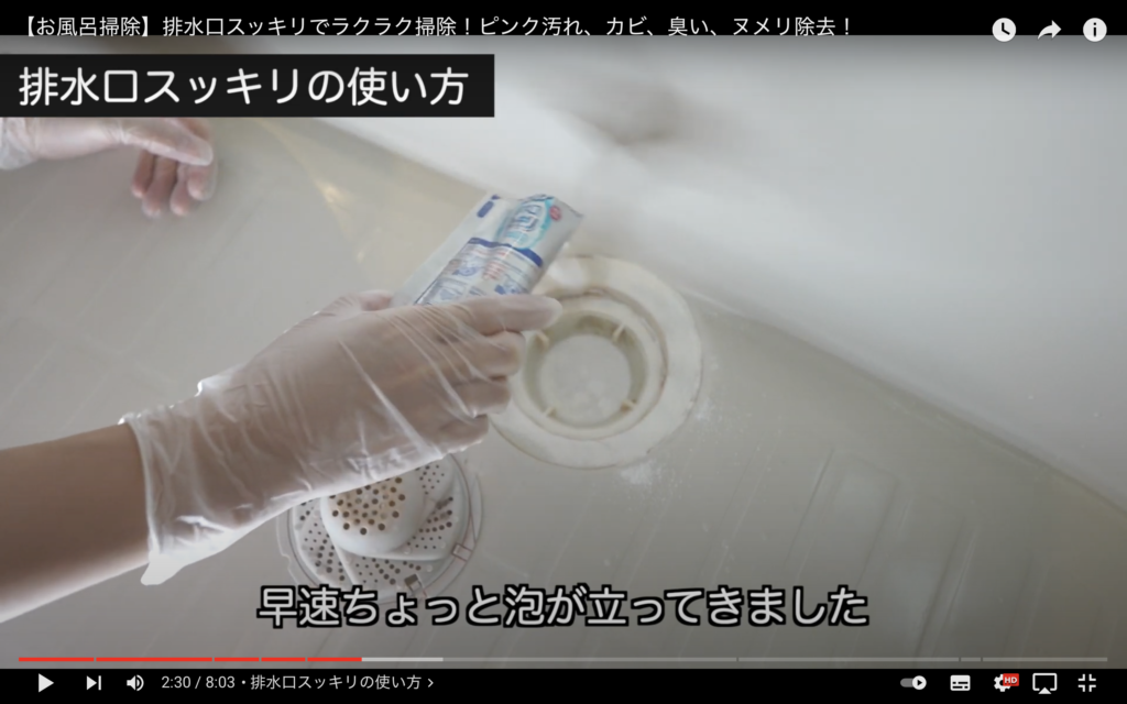 掃除塾のミナミさんが、蓋を外した状態のお風呂の排水溝に、カビハイター排水溝スッキリの一袋分の粉を振りかけている画像。