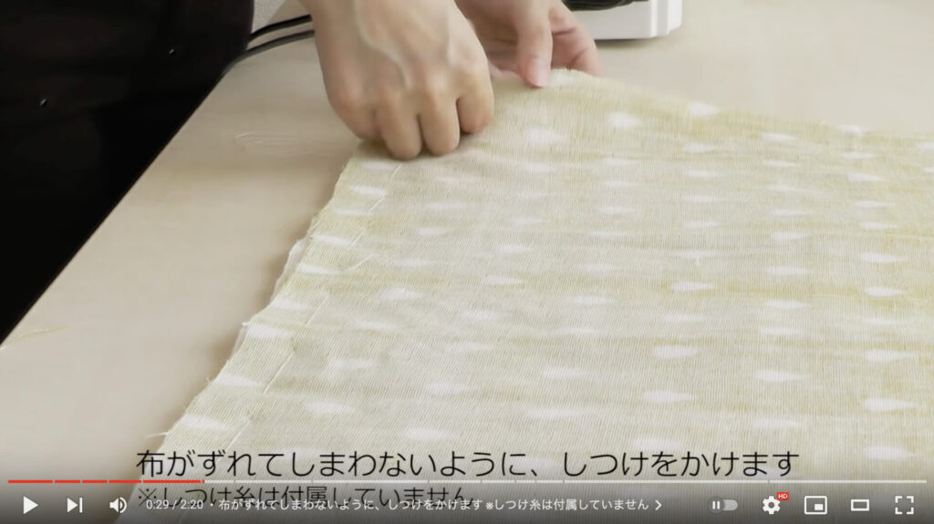 布のズレ防止のためにしつけ糸で縫っている様子。