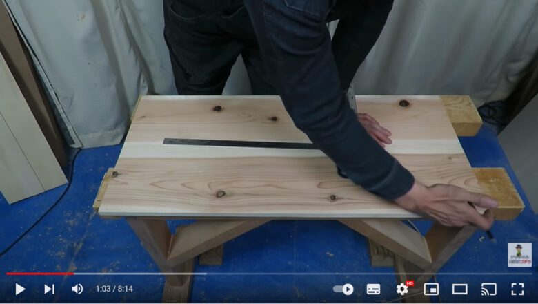 材料の木材につけた線のどの部分を切ればいいのかを説明している様子