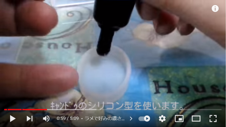 楕円形のシリン型に、レジン液を流し込む場面。画面には、それがキャンドゥの商品であることを伝える字幕が入っている。