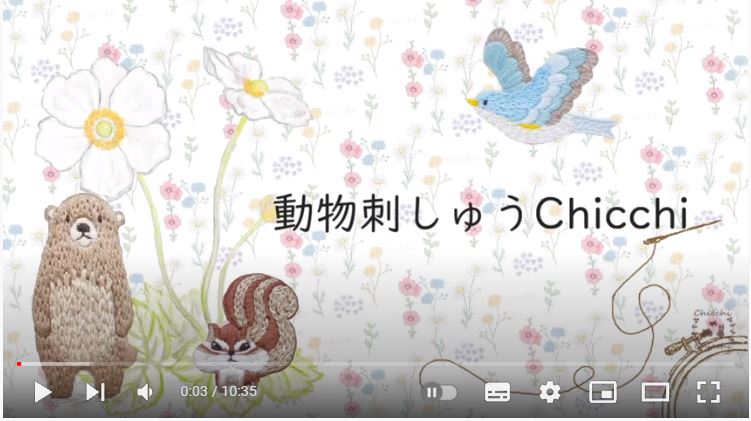 花柄の背景　左下にクマが二本足で立っている刺繍、リスの刺繍　右上に青い鳥の刺繍