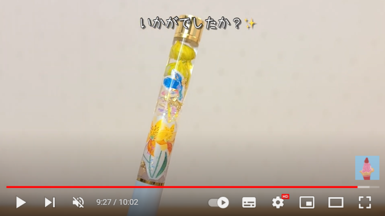 完成したボールペンが画面にアップになって映っている。黄色の花素材と、同じく黄色い花のイラストが調和し、明るい印象の作品に。