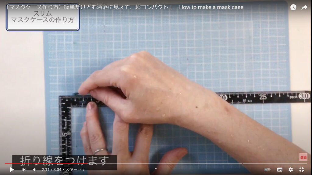 マスクケースの作り方で、折り目をつける作業を説明している動画で「折り線をつけます」という文が表示された画像。
