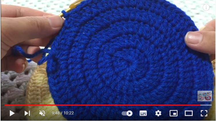 青い毛糸で円を編んだものを見せている画像