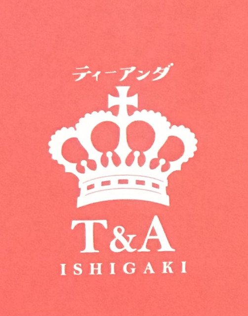 都築麻衣さんのショップ「T&A ISHIGAKI」のロゴの画像です。鮮やかなオレンジに、王冠とショップの名前が書かれています。
