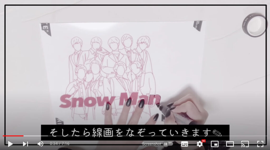 アイドルグループ「Snow Man」の線画デザインを、プラ版に黒マジックで写している写真。