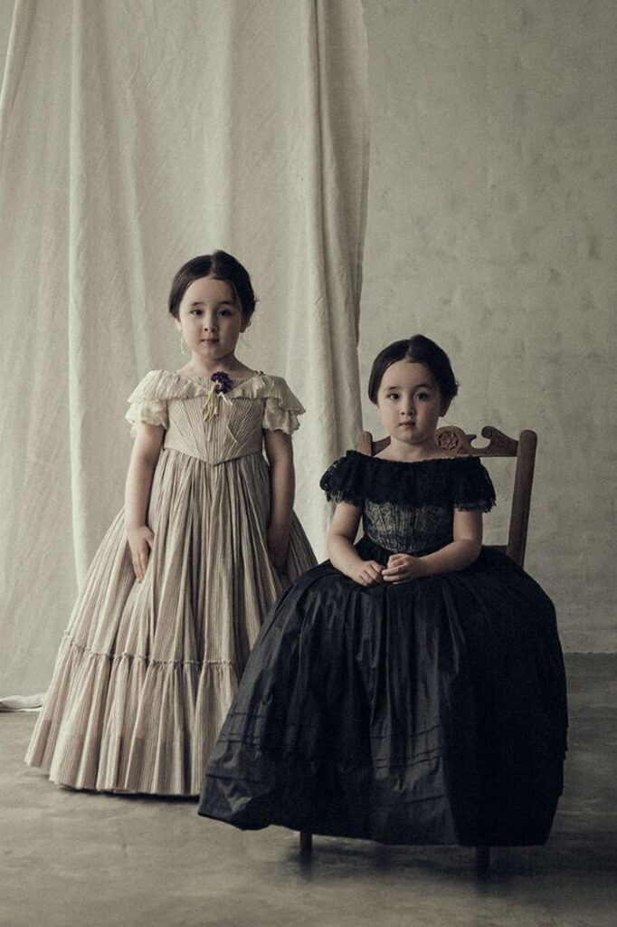 「Ingrid」という商品の写真。双子の女の子が、一人は立ってもう一人は座っている。