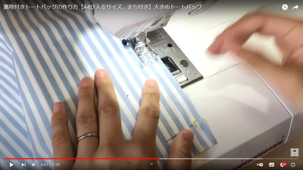 トートバッグを作る作業を解説している動画で、生地をミシンで縫っている様子を表示した画像。