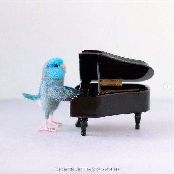 青い小鳥メルリルハが立ってピアノを弾いている街角ミュージシャン