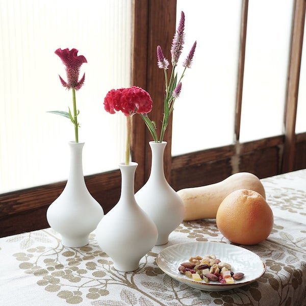真っ白でシンプルな形の花瓶が、挿した花の個性を際立たせます。