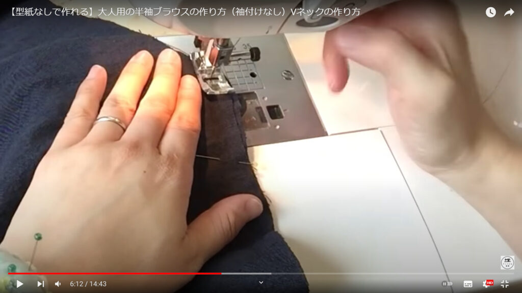 前身ごろと後ろ身ごろを縫い合わせる作業を解説している動画で、ミシンで前後の身ごろを合わせて、縫っている画像。