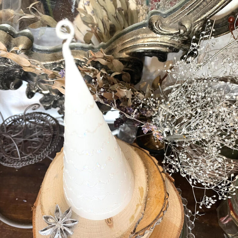 「ツリーキャンドル p」という商品の写真。クリスマスツリーの様な形をしたキャンドルが、飾られている様子。