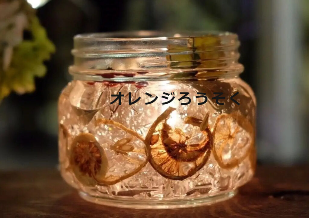 上平敏子さんが運営しているお店のロゴマーク。中央に店名の「オレンジろうそく」と書かれていて、その後ろにはオレンジが使われたろうそくが置かれている。