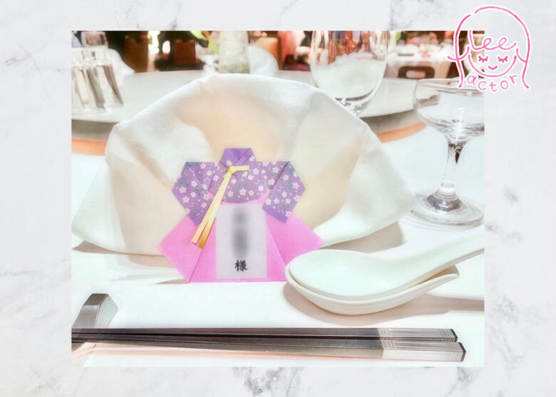 「席札/チマチョゴリ」という商品の写真。席札が実際に披露宴会場のテーブルに置かれている様子。