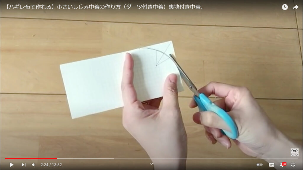 型紙を作る作業を解説している動画で、型を書いた紙をハサミで切り取る画像。
