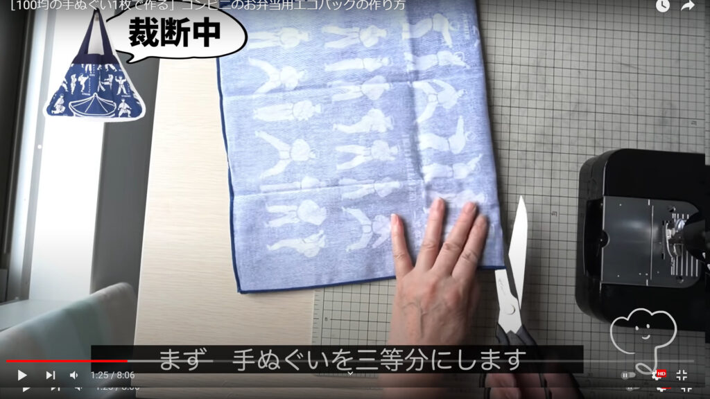 コンビニ用エコバッグの作り方で裁断と縫製の作業を解説している動画で、3等分にした手ぬぐいをハサミで裁断している様子を表示した画像。