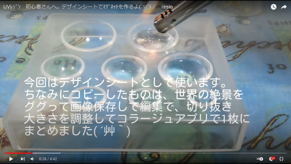 動画の冒頭部分で、丸いレジン型に液が流し入れられている場面。気泡を取り去る裏技を行おうとしながら、作品作りに使用したデザインシートについても触れている。