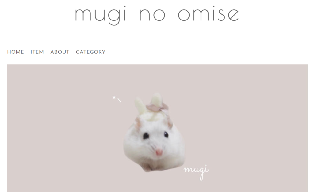 上瀬菜里さんが運営するネットショップ「mugi no omise」のトップ画像です。白いハムスターにうさぎの帽子がのっている画像です。