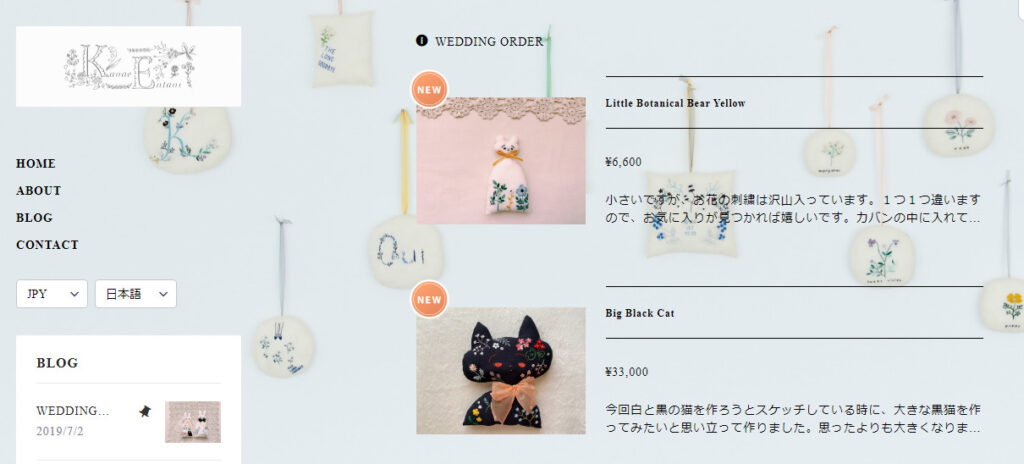 kanae entani embroideryのトップ画像。水色のカラーに、左上にショップ名、真ん中に商品の猫の刺繍をしたものが２つ並んでいる。