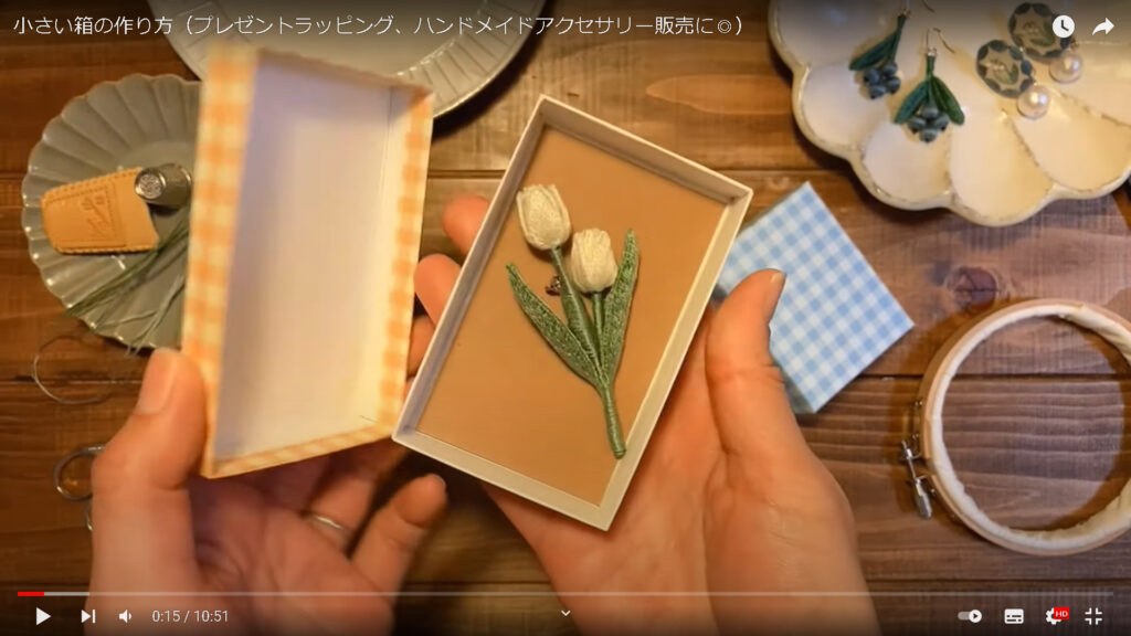 今回、作り方を教えてくれる箱に、aoneco.さんの作品であるお花のブローチを入れて見せている場面です。
