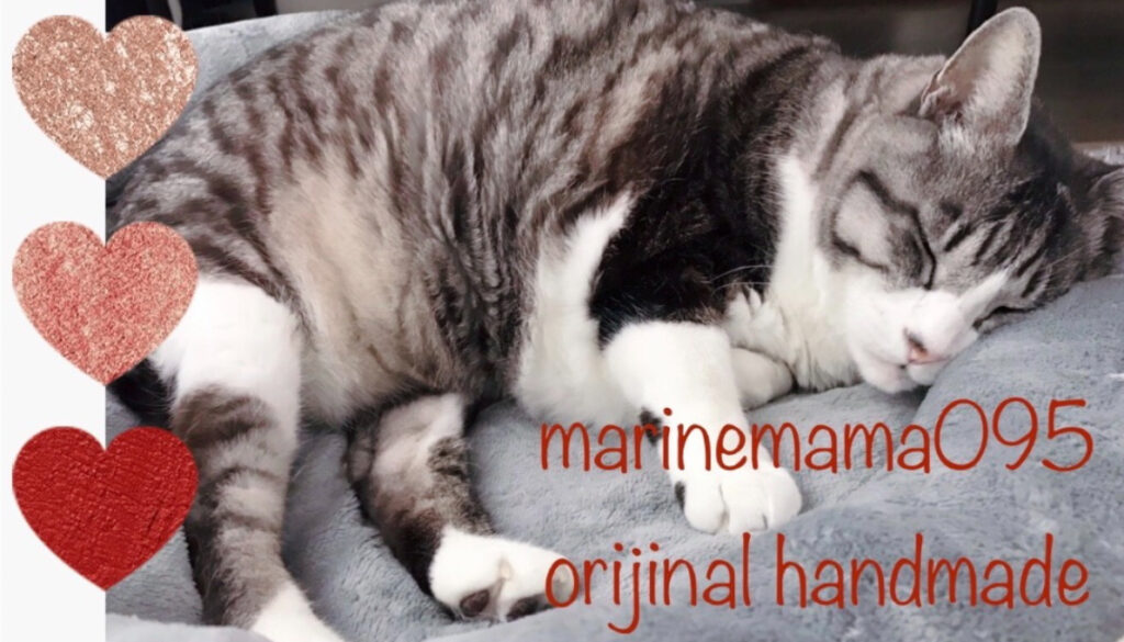小林真由さんのショップmarinemama095のトップ画像、寝ている猫の写真の上に英文字が描かれている
